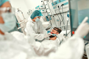 图为，在现代医院重症监护室，身穿防护服的医生给正在接受治疗的新冠肺炎患者戴上了口罩。