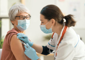 医生给一名妇女接种疫苗