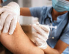病人接受医学专业人员在上臂注射疫苗的病人