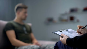 心理学家在与男士兵的治疗期间做笔记