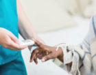 一名护士用手持设备检测病人血糖的图像。