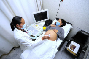 孕妇戴着口罩接受超声波扫描